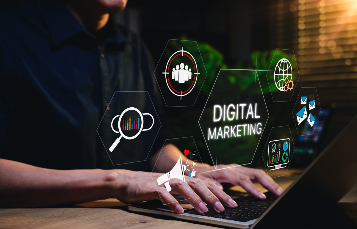 Person using laptop with digital marketing icons