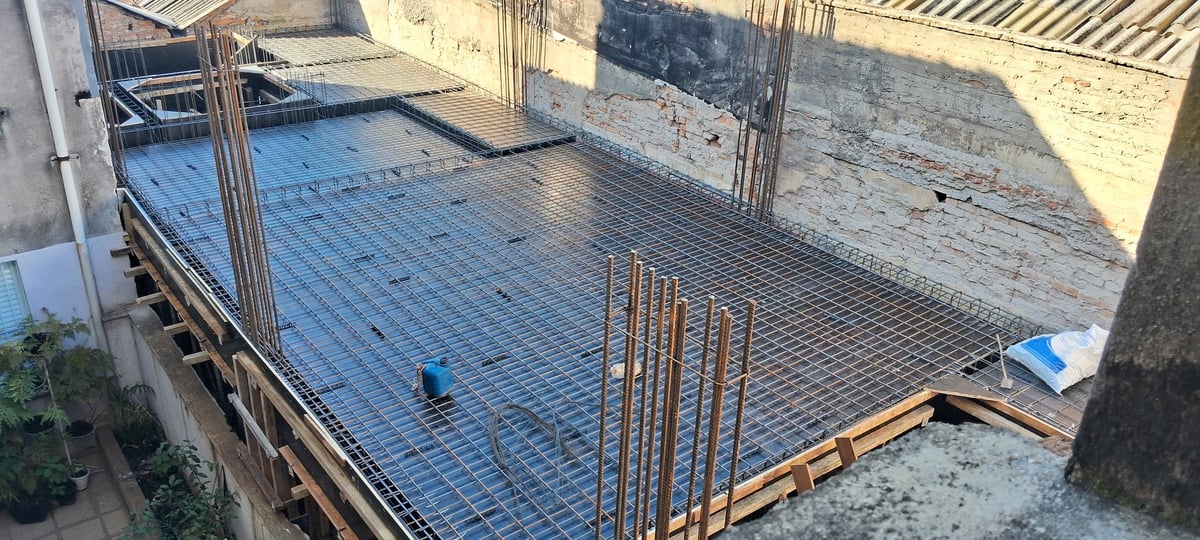 Steel rebar mesh framework being prepared for pouring concrete on a residential construction site